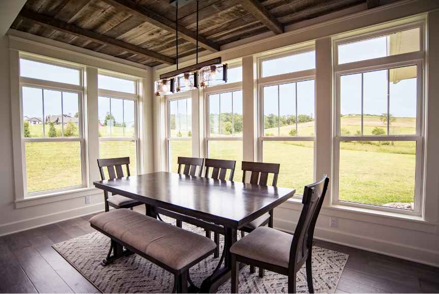 interior photo of a dining room table surrounded by double hung windows