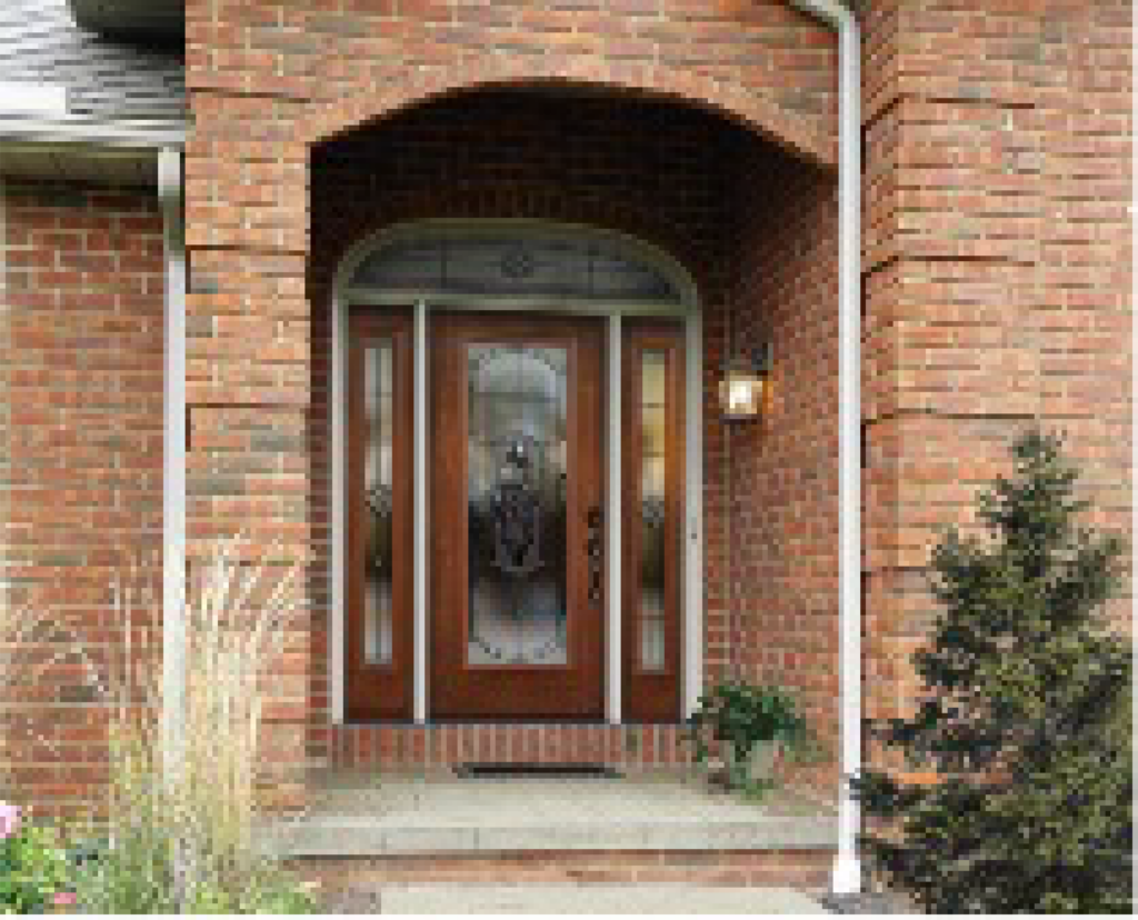 a brick house with a wood and glass front door