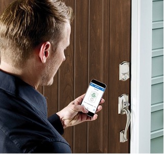 a man using his smartphone to use the schlage electronic keypad and deadbolt