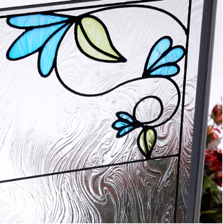 a close up photo of stained glass depicting blue flowers with green leaves